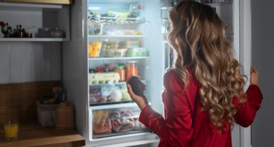 medium-shot-woman-checking-fridge-night_23-2150301909