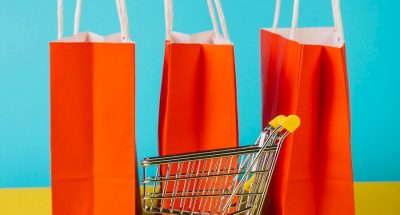 sales-concept-with-cart-front-orange-shopping-bags_23-2147730837