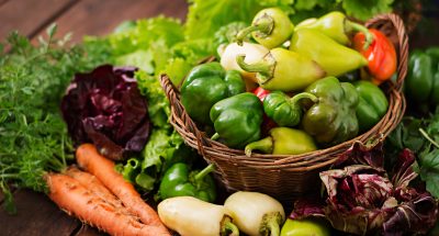 Assortment of vegetables and green herbs. Market. Vegetables in a basket on a dark background