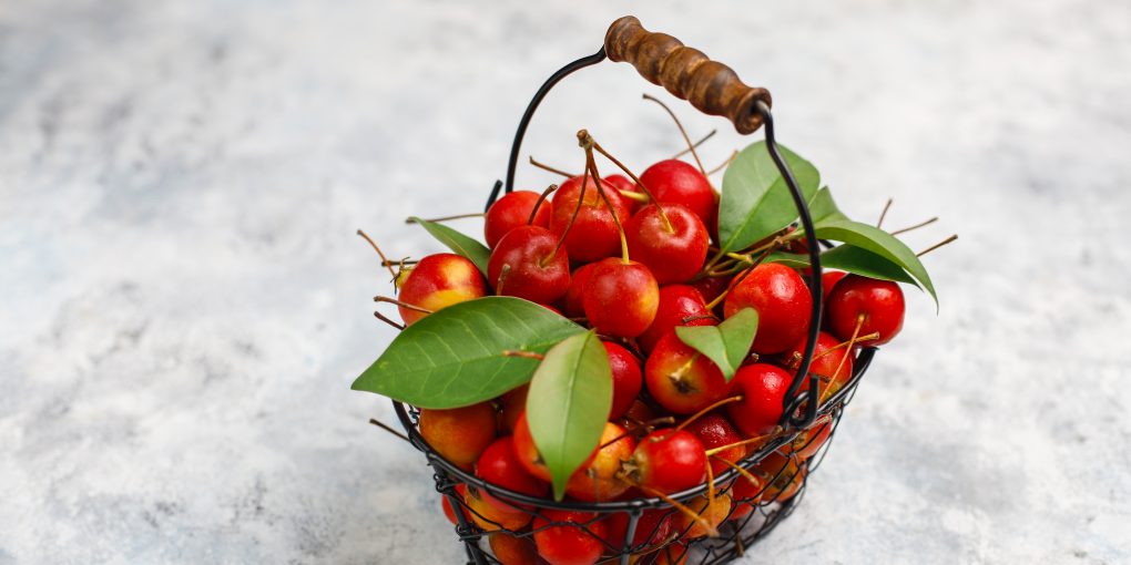 Ripe red apples in storage food basket on concrete background,sp