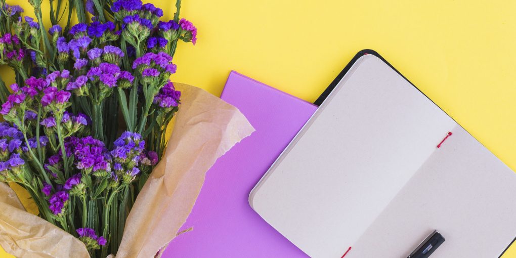 buket-cvetov-dnevniki-i-rucka-na-zeltom-fone