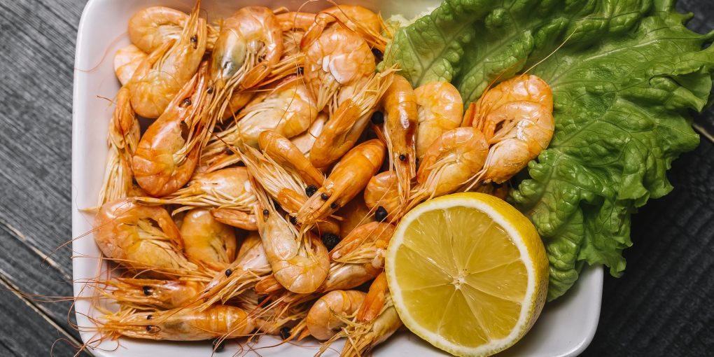 top view boiled river shrimps on a leaf of lettuce with lemon