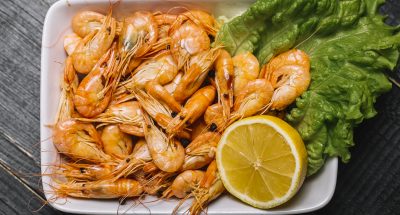 top view boiled river shrimps on a leaf of lettuce with lemon