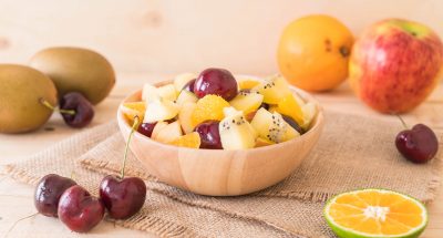mixed sliced fruit in wood bowl