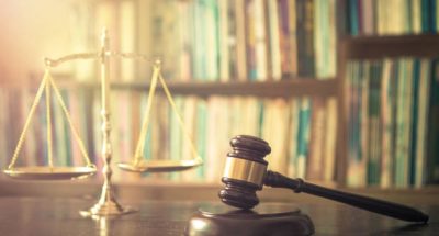 Judge gavel with scales on blurred library background