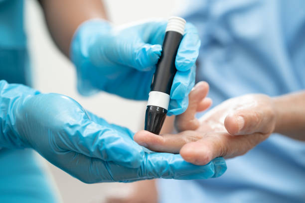 Doctor check diabetes from finger blood sugar level with finger lancet.