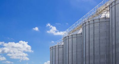 agriculture tank against blue sky background, seed steel silos, grain metal storage container.