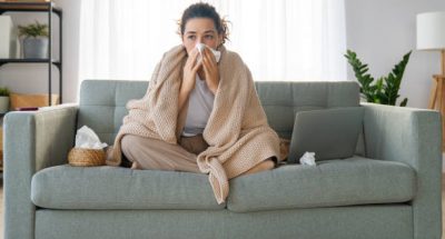 Ill upset girl is holding paper tissue and blowing nose. Virus symptom concept.