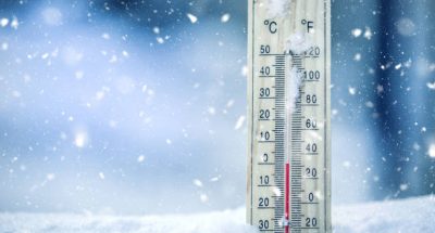 Thermometer on snow shows low temperatures - zero. Low temperatures in degrees Celsius and fahrenheit. Cold winter weather - zero celsius thirty two farenheit.