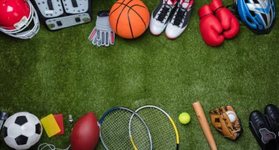 High Angle View Of Various Sport Equipments On Green Grass