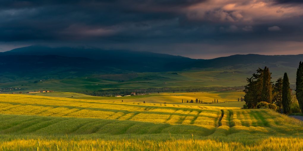 A beautiful scenery of a field surrounded by hills in the countryside