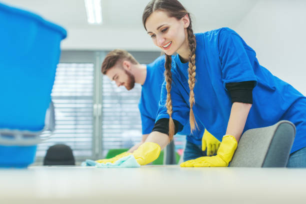 Cleaning crew wiping desks in an office building