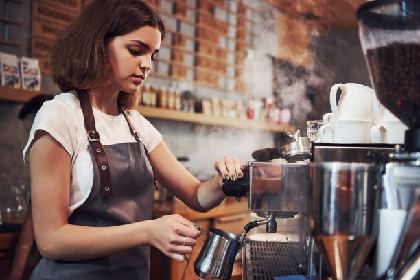 That's how fresh drink makes. Young female cafe worker indoors. Conception of business and service.